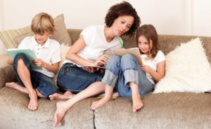 Mom and two kids on the couch looking at papers